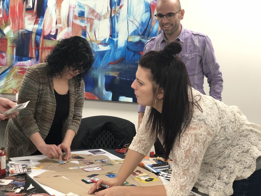 A small group building a shared collage at a table