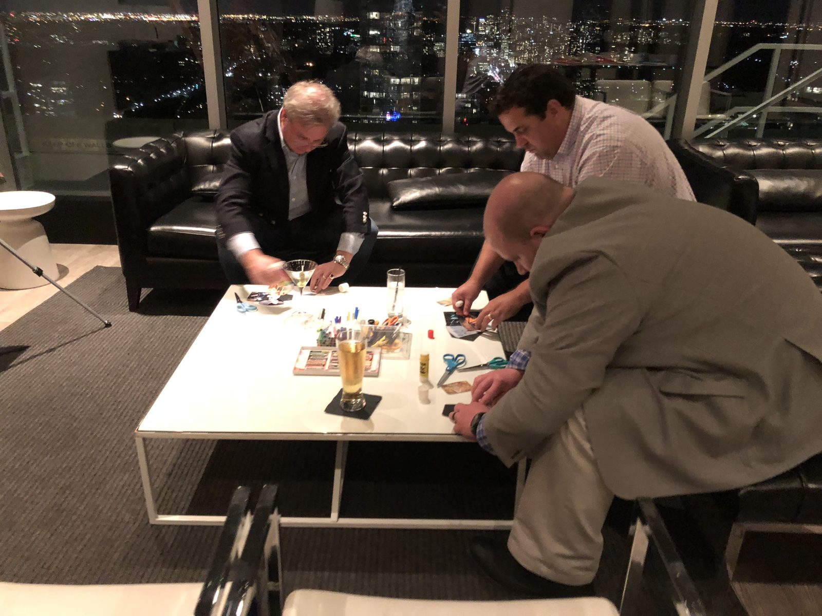 Three guests making collages at a coffee table