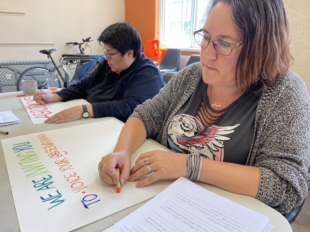 Participants writing feedback on a banner