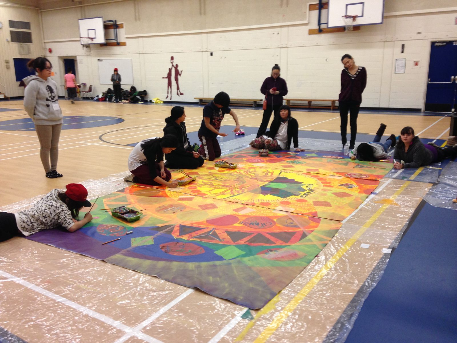 People from different groups at round tables in a shared workshop